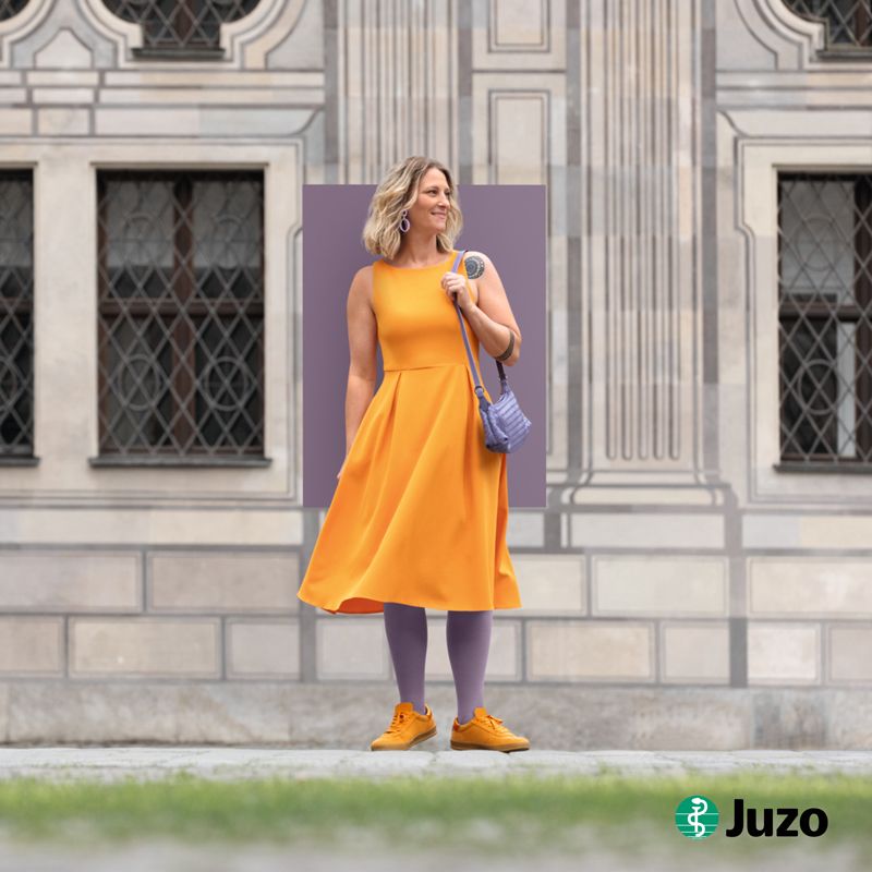 Kompressionsstrümpfe Lipödem und Lymphödem Trendfarben 2026 Violet Juzo Die Frau steht vor einem Schloss und trägt Kompressionsstrümpfe in violet von Juzo zur Kompression bei Lipödem und Lymphödem.