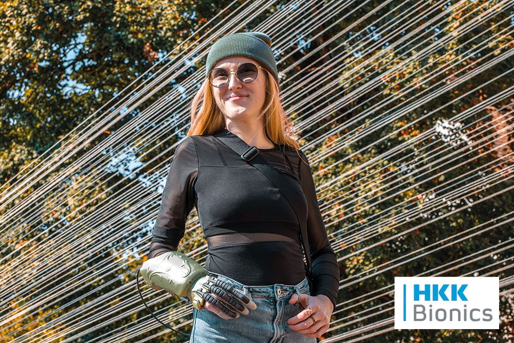 Eine Frau mit Handlähmung trägt die exomotion hand one Handorthese von HKK Bionics.