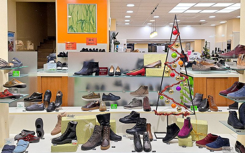 Hallplatz 5 - Schübel & Hofmann Gesunde Schuhe Schaufenster des Schuhgeschäfts mit ausgestellten Winterschuhen und Weihnachtsdekoration