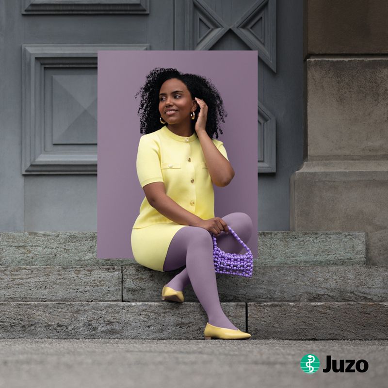 Eine Frau sitzt auf der Treppe und trägt Kompressionsstrümpfe von Juzo zur Kompression bei Venenleiden.