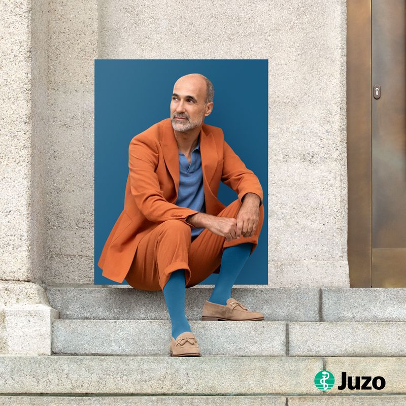 Ein Mann sitzt auf der Treppe und trägt Kompressionsstrümpfe von Juzo zur Kompression bei Venenleiden.