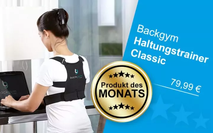 Eine Frau steht am Tisch und arbeitet. Sie trägt den Rückenhaltungstrainer „Backgym Haltungstrainer Classic”.