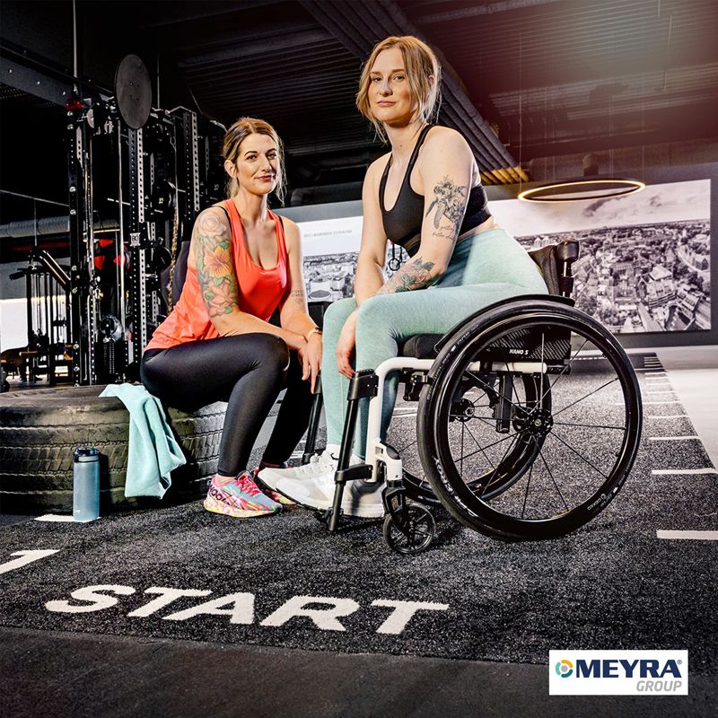 Eine Frau trainiert im Fitnessstudio mit dem Rollstuhl von Meyra.